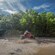 A man drives his ATV through a huge mud puddle in a forest